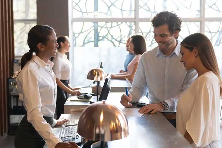 People-at-a-hotel-enjoying-their-vacation-checking-in-filling-a-form-smiling